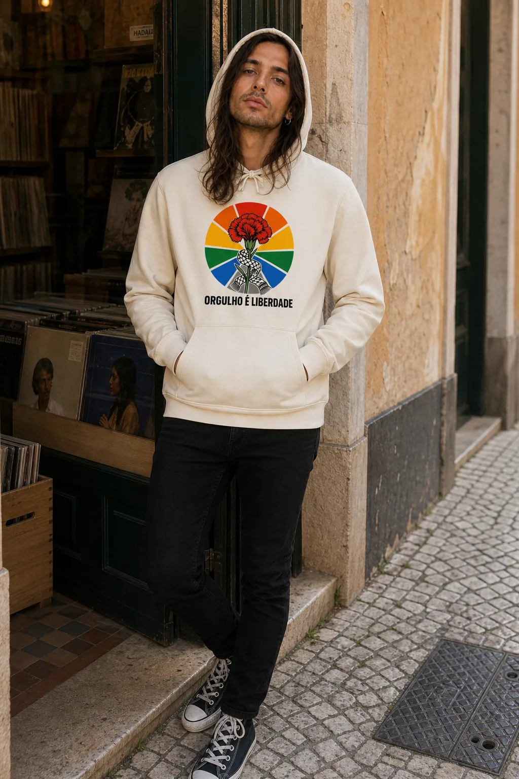 Pessoa a vestir o Hoodie Orgulho é Liberdade em ivory, capuz vestido, com o cravo e o arco-íris ao peito